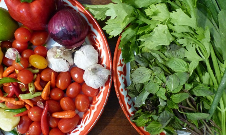 Mixtures of Rosa's Thai fresh ingredients such as tomatoes. onions and herbs in two large bowls