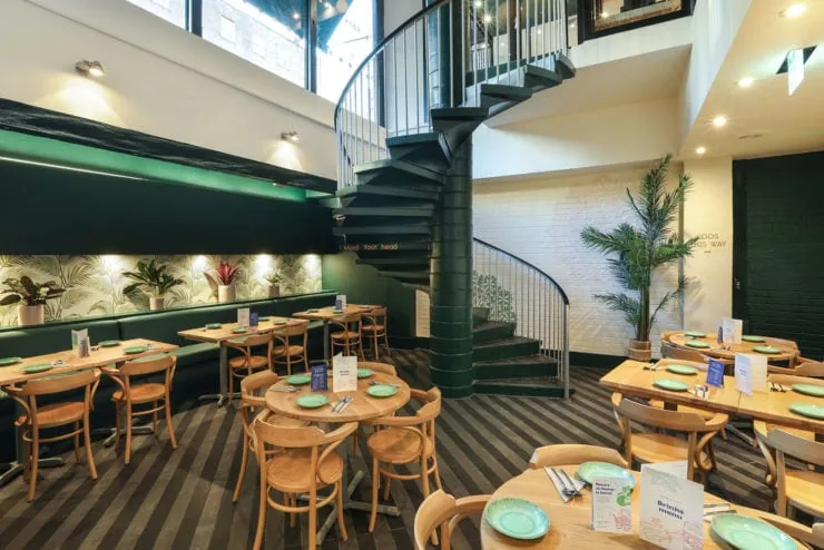 light filled restaurant with green interior and warm wood