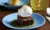 brownie with sticky sauce and ice cream on blue plate