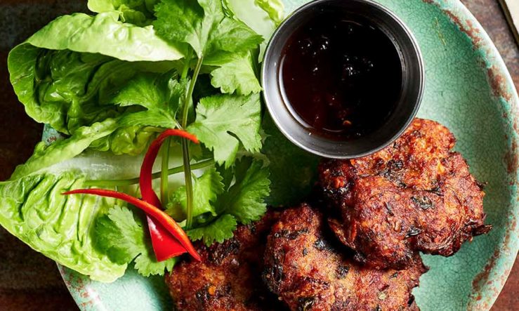 Rosa's Thai larb patties on a pale green plate with salad garnish and tamarind sauce