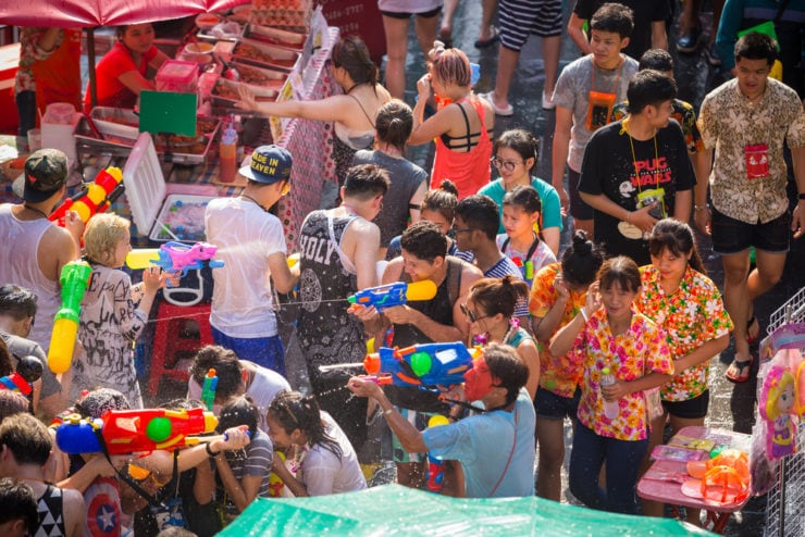 People in colourful shirts with water pistols in the Songkran water festival in Thailand