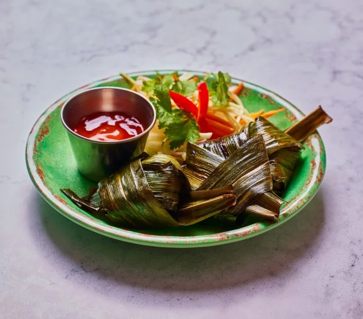 food wrapped in leaf on green plate