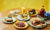 Thai breakfast spread in colourful plates with yellow background