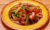 Chilli basil stir fry with vegetable served in a yellow plate on a wooden table