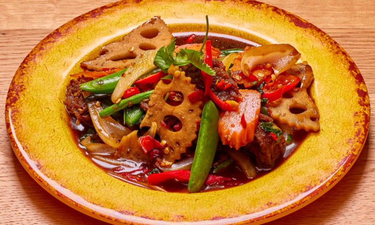 ChilliBasilStirfryVeg Chilli basil stir fry with vegetable served in a yellow plate on a wooden table