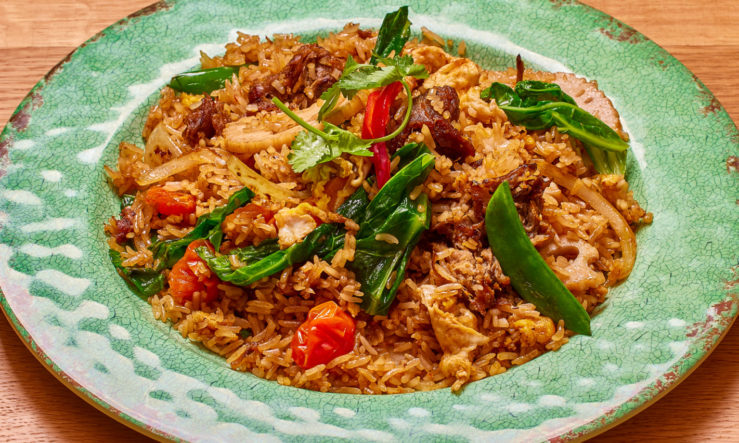RosasFriedRIceVeg Fried rice with vegetables served in a green plate on a wooden table